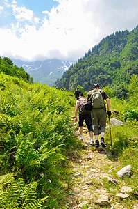 年轻的徒步旅行者在瑞士的阿尔卑斯山徒步旅行 那里有群山图片