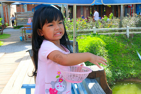 漂亮女孩在喂鱼池塘旅游家庭花园旅行建筑学公园反射婴儿宗教图片