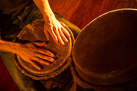 人们用手在djembe鼓里演奏音乐男人乐器木头雷鬼女孩爱好皮革韵律吊带手鼓图片