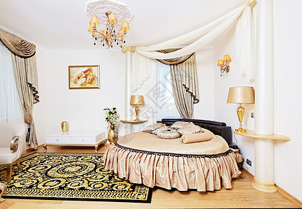 金色古典卧室室内 有圆床和小桌图片