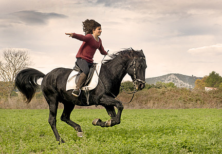 女童和黑马女士骑士运动动物骑马黑色场地青少年骑术舞步背景图片