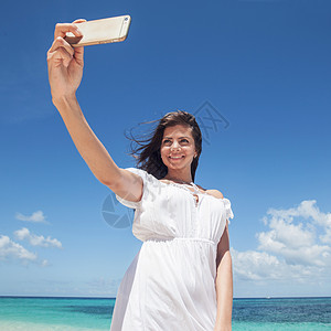 女人在海滩上自拍照片白色裙子摄影热带细胞女孩海洋旅行假期图片