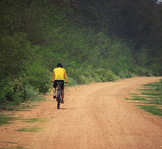 青年男子骑着山地自行车 在废尘路上使用 用于运动列苏旅行骑士山地车运动员娱乐闲暇安全锻炼爱好成人图片