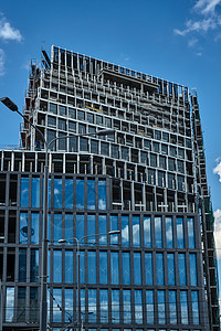 正在建造的一座摩天大楼的金属建筑窗户地面男人天空脚手架绳索建筑学劳动者机器高楼图片