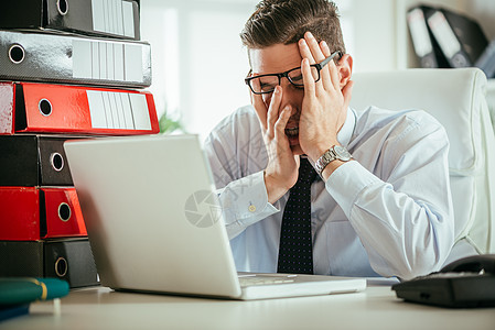 疲累的商务人士工人活页工作男人笔记本眼镜电脑经理压力办公室图片