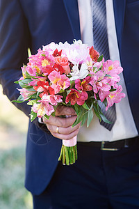 新郎在婚礼那天拿着新娘的花束图片