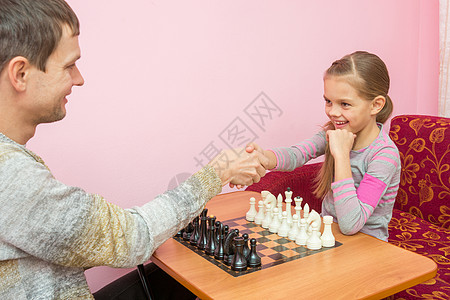 爸爸和女儿互相亲手打招呼 准备玩下棋游戏背景图片