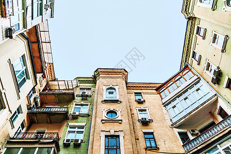在高耸的老房子里从下往上看景观街道建筑学蓝色天空玻璃阳台建筑住宅窗户图片