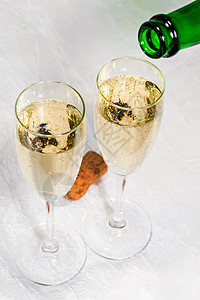 香槟倒在两杯杯子上 紧闭酒精水晶桌子瓶子漩涡饮料纪念日派对软木液体图片