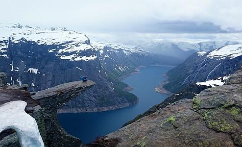 挪威 Trolltunga蓝色水面巨魔海岸线成人阳光对象男士远足岩石图片