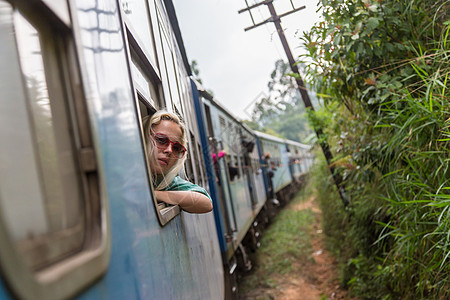 金发美女在火车上 看着窗边的深渊国家假期车皮运输女孩方式太阳镜铁路乘客焦点图片