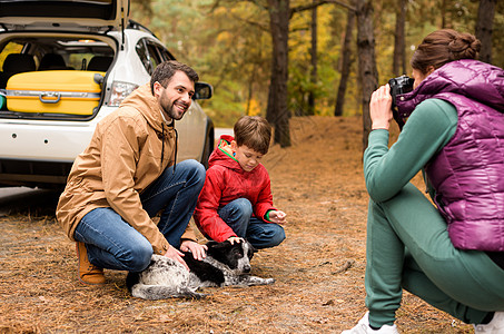 幸福的家庭在森林里玩狗图片