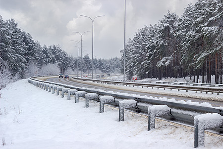 下雪后两边都有森林的高速公路图片