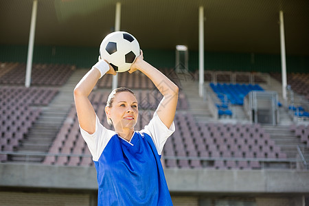 女足球运动员女橄榄球员即将扔一个足球赛女士运动员快乐足球体育场运动女性练习专注福利背景