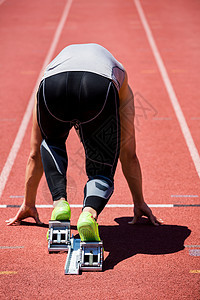 在即将运行的起始街区中的 Athlete体育场赛跑者竞技男性起跑线挑战晴天专注运动服运动员图片