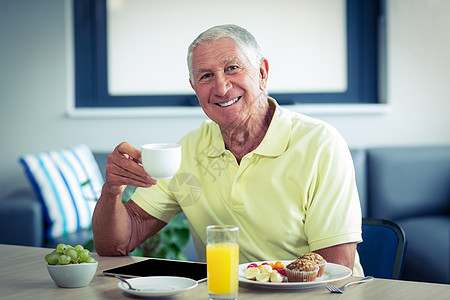 老年男子与早餐一起喝茶图片