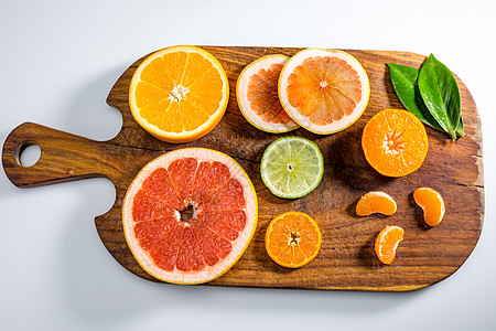 各种新鲜柑橘水果和白板切片上的叶子的顶部视图图片