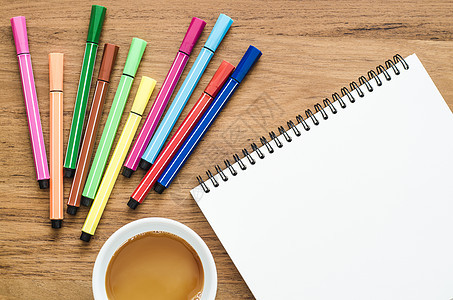 配有笔记本 彩笔和咖啡的木质桌床单教育桌子笔记铅笔职场工作桌面杯子商业图片