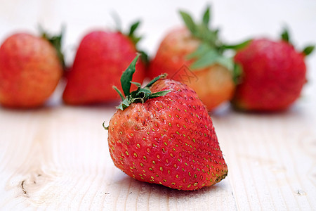 桌木上的红草莓组宏观叶子健康水果食物木头白色绿色红色甜点图片