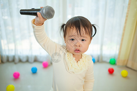 小女孩唱歌带麦克风的亚洲小女孩喜悦歌手情感乐趣歌曲女孩唱歌工作室童年房子背景