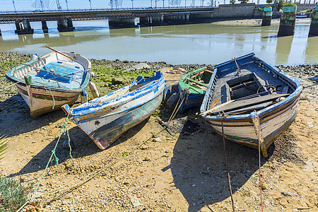 河岸上的旧渔船在河流沿岸的旧渔船场景木头支撑反射运输晴天边缘环境蓝色钓鱼图片