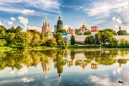莫斯科Novodevichy修道院的Idillic观点宗教地标建筑新圣女天炉大教堂蓝色池塘金子圆顶图片