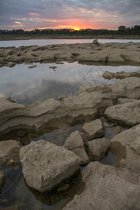 潮池和日落光流风暴河岸岩石海岸线支撑化石河床化石场光束图片