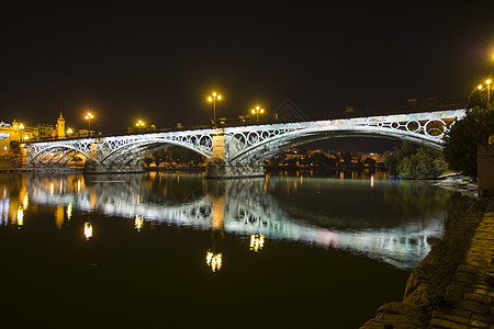 西班牙塞维利亚三亚纳大桥夜景 也称我手表灯光地标历史性栏杆历史运输假期建筑学反射图片
