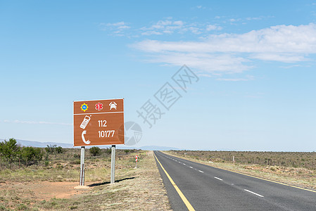 蓝天公路带有紧急电话号码的公路标志背景