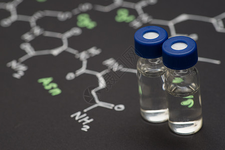 特写蓝色盖帽样品瓶在纸上的化学式器皿技术实验室管子学家样品生物化学荷尔蒙科学图片