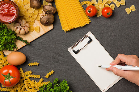 意大利意大利意面照片食谱 手拿笔写在空白上背景图片