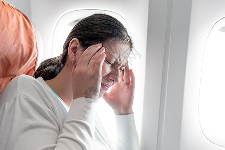 一名在飞机上头痛的妇女的肖像图片