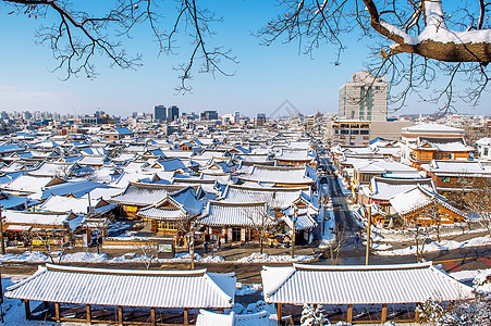 南韩冬季的青州花木村村 Jeonju传统朝鲜村庄屋顶上布满雪雪景蓝色场景丘陵建筑物雪花天际公园天空降雪图片
