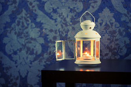 木制桌上有白蜡烛的铁灯笼高清图片