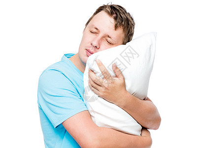 睡梦中的男人拥抱软枕头 在白色背景下图片