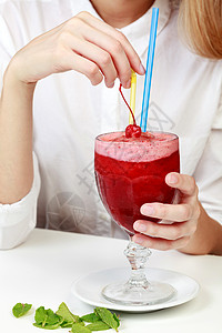 樱桃冰淇淋 在一大杯玻璃杯里 用两个吸管在女人的公顷水果排毒稻草玻璃饮食薄荷食物树叶牛奶饮料图片