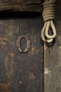 生锈的马掌和 rop乡村绳索橡木房子安全出口金属古董环形木材背景图片