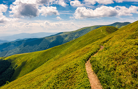 穿过山脊的河道小路顶峰风景上坡天空高山踪迹天气草地旅行背景图片