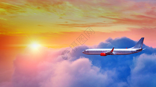 飞机在日落的光线下飞越云层上空假期高清图片素材