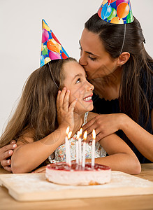 拿着蜡烛女孩这是我的生日女性女士蛋糕礼物妈妈微笑快乐女孩庆典桌子背景