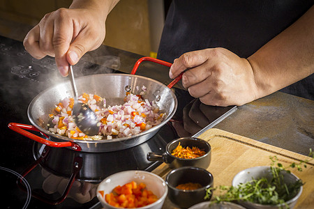 厨师正在煎煮烹饪辣椒酱的食品配料图片