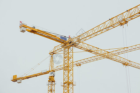 贝尔市冬季许多黄黄色建筑起重机的建造图片