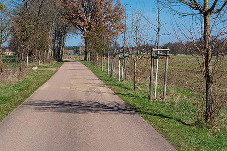 两个村庄之间的乡村公路牧场平原生态天空农田草地缠绕条纹沥青导柱图片