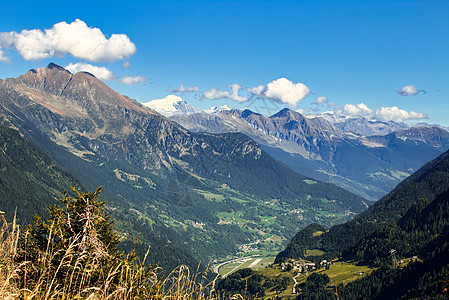 从瑞士的Gotthard通行证查看蓝色山峰太阳远景农村风景树木旅行天空建筑物图片
