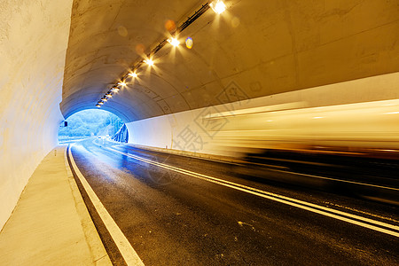 公路隧道有灯光的隧道石头环境运动运输天空交通沥青白色旅行速度背景