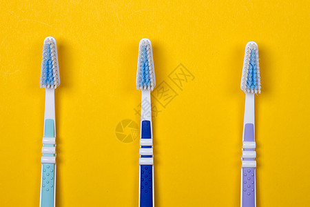 三个黄色背景的牙刷 W牙齿医疗药品塑料牙膏蓝色呼吸保健健康清洁工图片