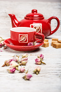 玫瑰果油玫瑰芽茶茶壶玫瑰红色桌子飞碟杯子背景