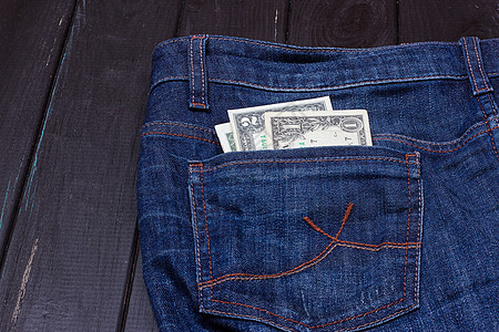 牛仔裤口袋里的美元帆布商业支付购物财富顾客钱包纺织品储蓄衣服图片