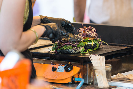 大厨在户外做牛肉汉堡 在开放的厨房国际食品节活动敷料垃圾午餐街道大车包子小吃盘子美食手套图片