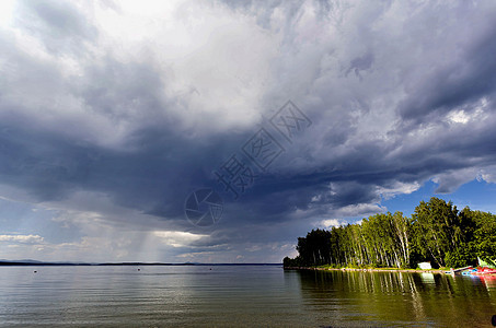 在湖上下雨前的乌云雨闪电场景海滩波浪风暴森林地平线木头气象天空图片